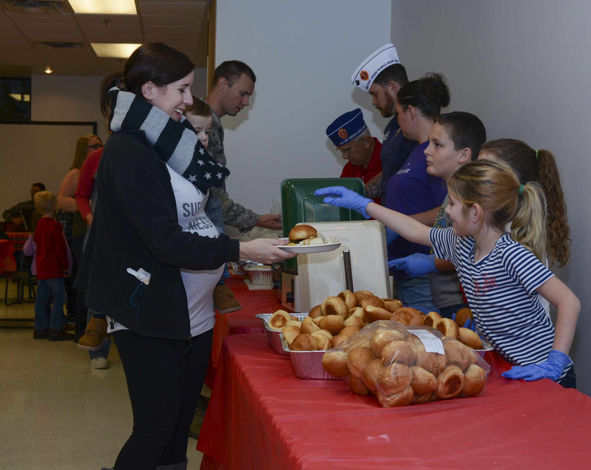 Volunteers serve food to guests during a holiday party, Dec. 15, 2017, at Moody Air Force Base, Ga. The Airman and Family Readiness Center hosted the event for families of deployed or remote-tour Airmen, and families enrolled in the Exceptional Family Member Program. During the party, families enjoyed a turkey dinner, played games, made arts and crafts for their loved ones and shared a special moment with Santa Claus. (U.S. Air Force photo by Senior Airman Lauren M. Sprunk)