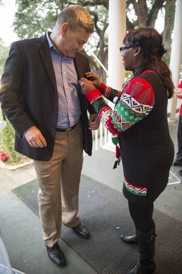 Beverly Boyd (right), the Marine Forces Reserve protocol officer, assists Greg Habel (left), the MARFORRES executive director, with his name tag at an annual Christmas party hosted by Lt. Gen. Rex C. McMillian, commander of Marine Forces Reserve and Marine Forces North, Dec. 16, 2017. Distinguished military officials and civilians attended the dinner to celebrate the holiday season and donate toys to Toys for Tots. (U.S. Marine Corps photo by Sgt. Nicole Pompei / Released).