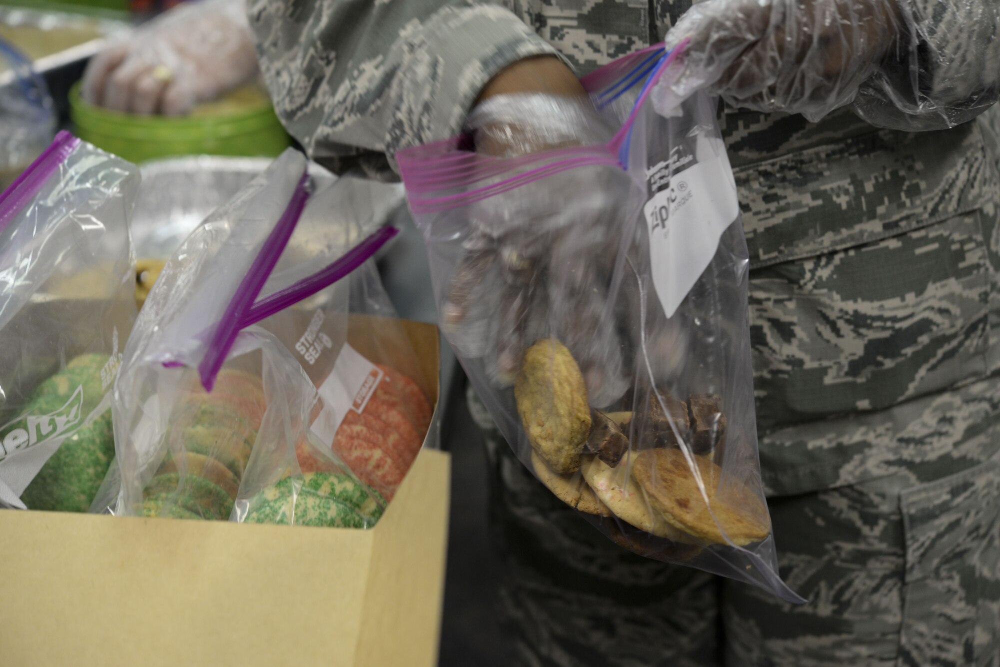 Chief Master Sgt. Kecia Uyeno, 436th Force Support Squadron superintendent packs a gift bag of cookies Dec. 18, 2017, during Operation Cookie Drop at the 9th Airlift Squadron on Dover Air Force Base, Del. The community donated enough cookies to provide a dozen cookies to 500 dorm residents, and supply the USO and the annual Feed The Troops Dinner with hundreds of cookies. (U.S. Air Force photo Staff Sgt. Aaron J. Jenne)