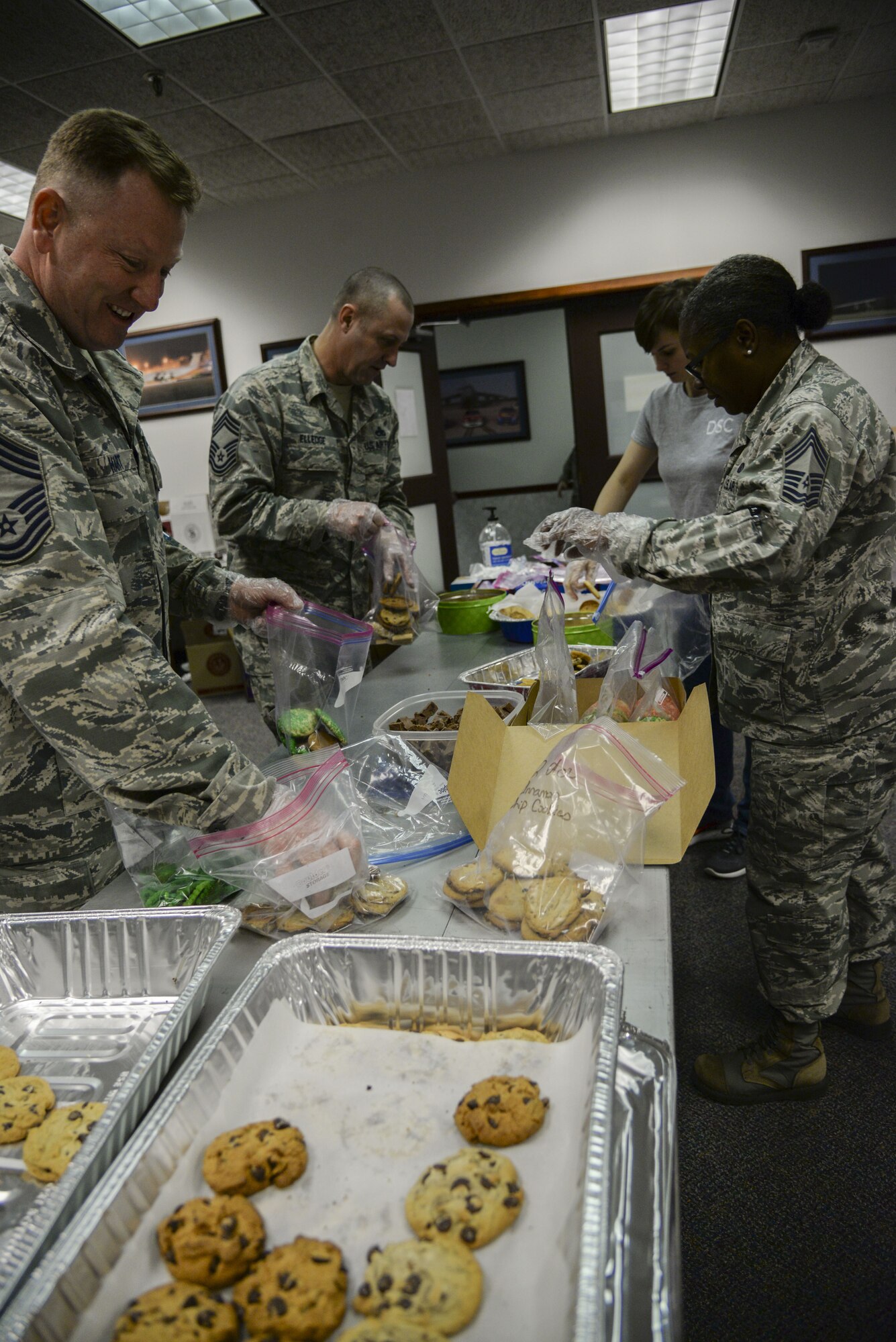 Team Dover leadership packages cookies Dec. 18, 2017, during Operation Cookie Drop at the 9th Airlift Squadron on Dover Air Force Base, Del. Volunteers packaged cookies during four, one-hour shifts to ensure every dorm resident received a dozen cookies during the holiday season. (U.S. Air Force photo by Staff Sgt. Aaron J. Jenne)