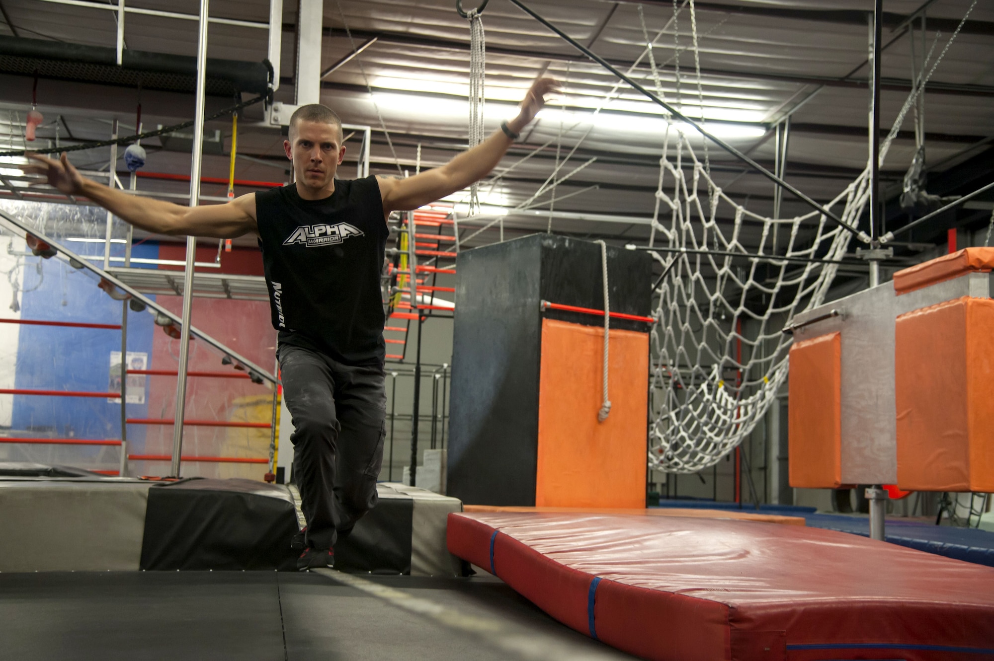 1st Lt. Eddie Hilburn, Air Force Research Lab optical physicist, maneuvers across a slack line at the Ninja Force Gym, Albuquerque, N.M., Dec. 4. Hilburn qualified for the Alpha warrior finals with a time of 50 seconds.