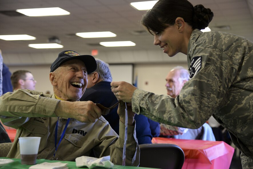 Navy veteran Carman Pecorelli shows pictures from his time in service to Civil Air Patrol Staff Sgt. Selena Copland, 075th Composite Squadron from Machias, Maine, Dec. 14, 2017, at the Camden-Wyoming Fire Company in Camden-Wyoming, Del. Pecorelli and Copland joined several others who traveled with the wreaths from Harrington, ME, to Arlington National Cemetery, Va., for a wreath-laying ceremony Dec. 16. (U.S. Air Force photo by Staff Sgt. Aaron J. Jenne)