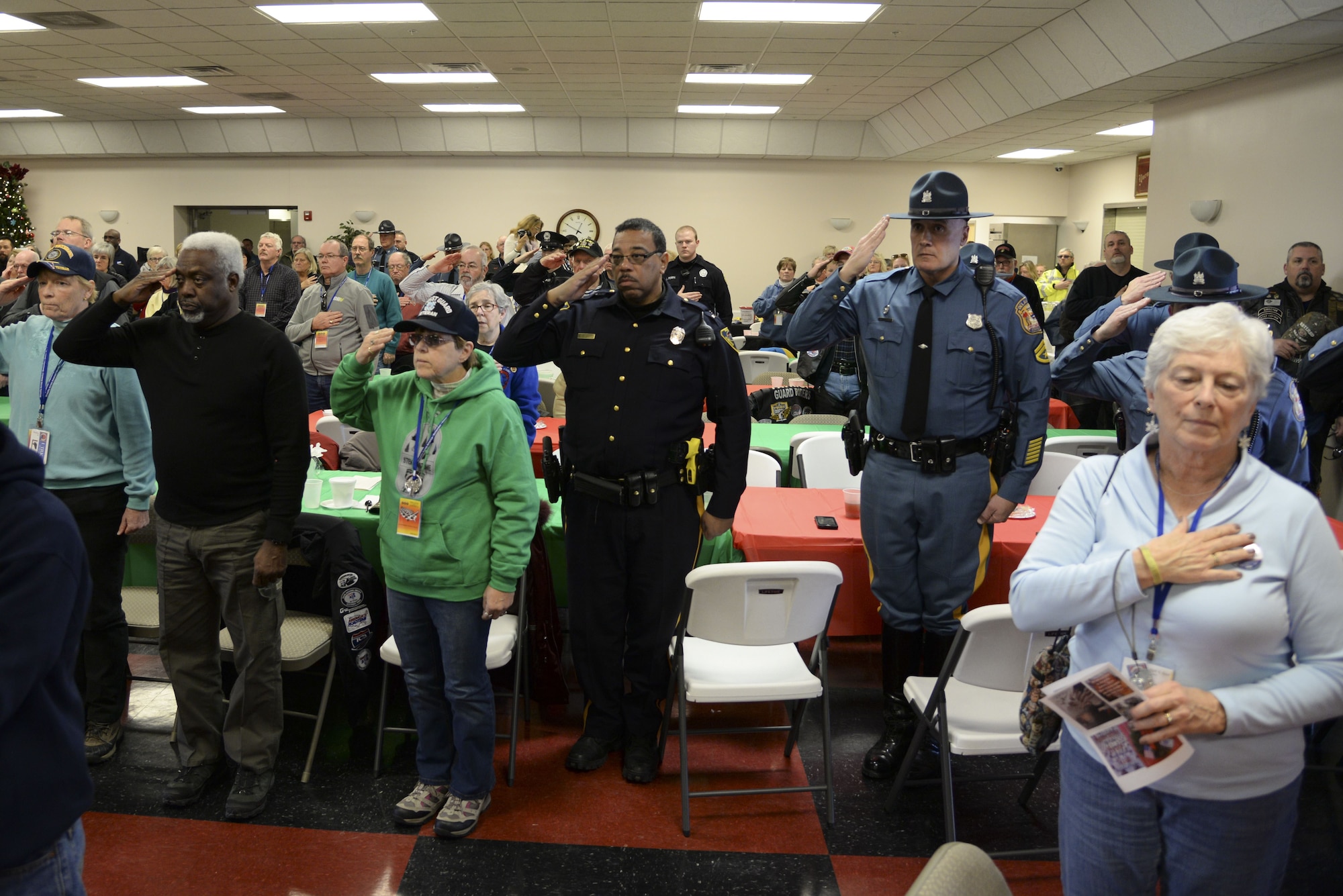 Local veterans, gold star families, community members, law enforcement and emergency management members salute as the Fifer Middle School’s Eighth Grade Chorus sings the national anthem Dec. 14, 2017, at the Camden-Wyoming Fire Company in Camden-Wyoming, Del. More than 150 community members came to honor their service members and veterans. (U.S. Air Force photo by Staff Sgt. Aaron J. Jenne)