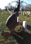Donald Adriance, veteran and member of the 436th Medical Group at Dover Air Force Base, Del., kneels before the gravesite of a fallen hero Dec. 16, 2017, at Arlington National Cemetery in Arlington, Va. Adriance was one of tens of thousands who volunteered to help place remembrance wreaths at headstones in the national cemetery in support of Wreaths Across America. (U.S. Air Force photo by 2nd Lt. Natasha O. Mosquera)