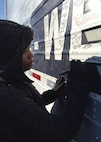 SrA Chelica Thompson, 436th Airlift Wing judge advocate general from Dover Air Force Base, Del., writes a message on one of the wreath-carrying trucks Dec. 16, 2017, at Arlington National Cemetery in Arlington, Va. Through personalized messages, volunteers expressed their gratitude for the fallen for all to see. (U.S. Air Force photo by 2nd Lt. Natasha O. Mosquera)