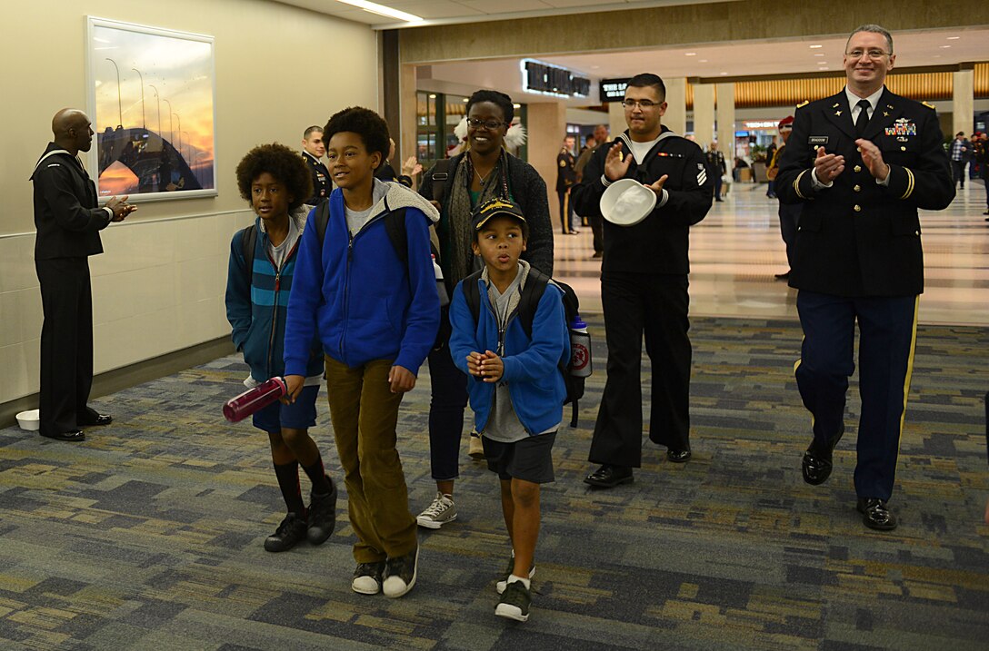 U.S. service members escort Gold Star families during the Snowball Express at Norfolk International Airport, Va., Dec. 9, 2017.