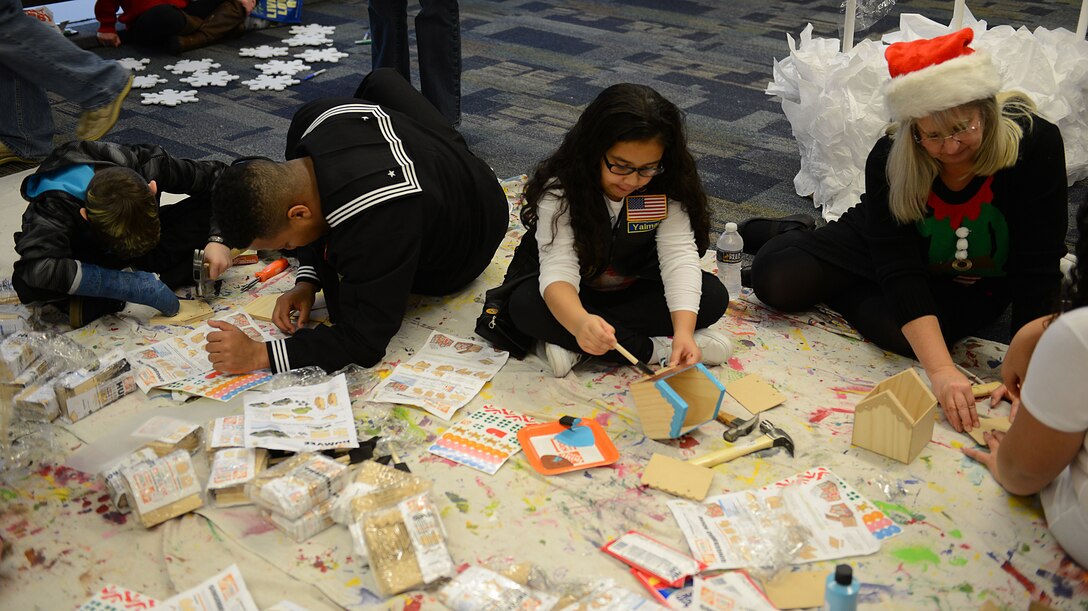 U.S. Service members and volunteers create crafts with Gold Star children during the Snowball Express at Norfolk International Airport, Va., Dec. 9, 2017.