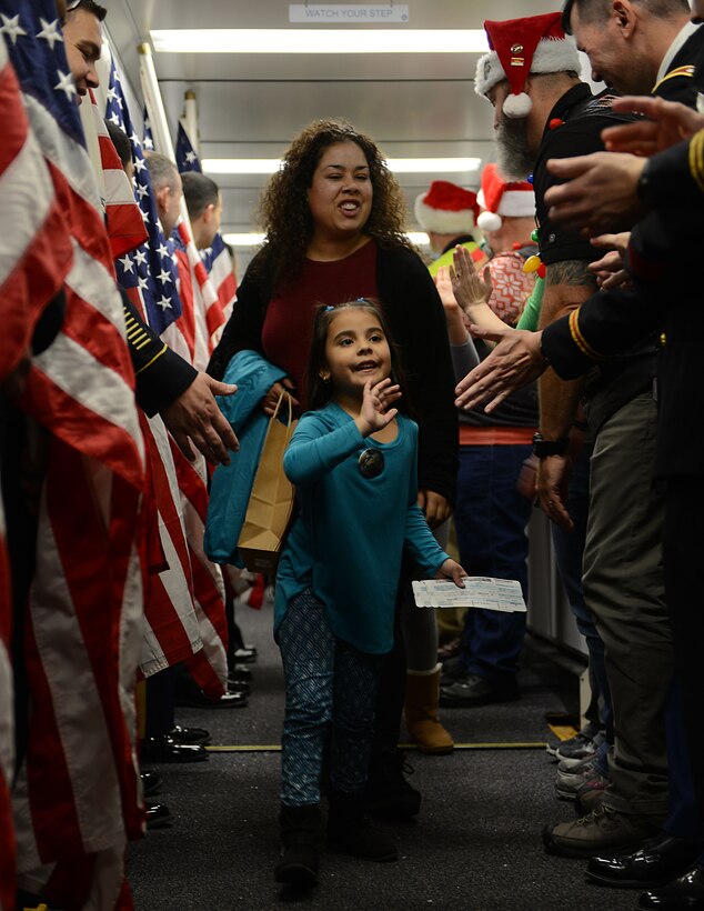 Gold Star family members Adriana Quintana, age 5, and her mother Nilda Quintana are escortedby U.S. Service members as they board the Snowball Express at Norfolk International Airport, Va., Dec. 9, 2017.