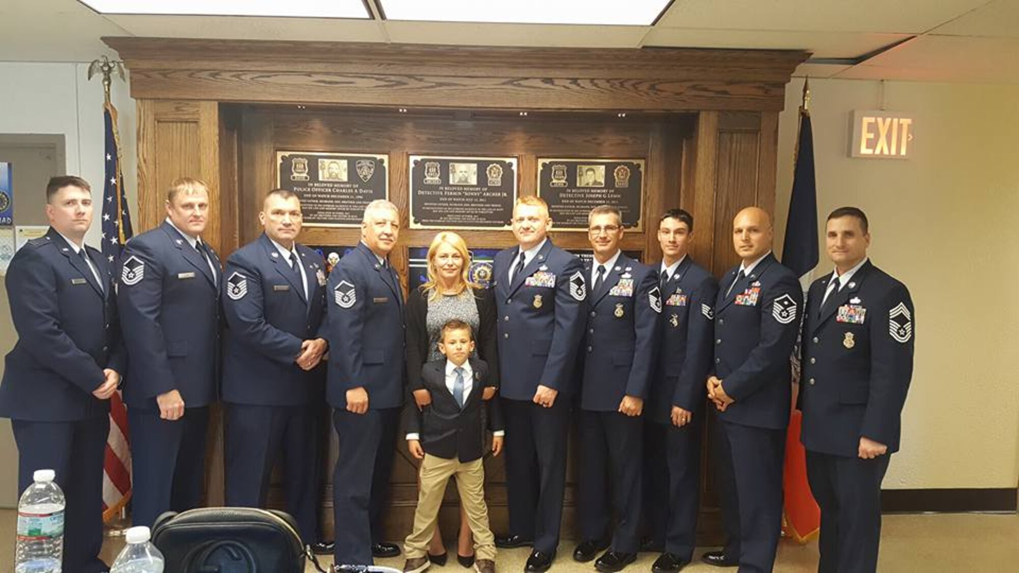 Airmen assigned to the 820th Base Defense Group and 105th Base Defense Squadron pose for a photo with Tech. Sgt. Joseph Lemm’s wife,  Christine DeGuisto and son, Ryan, during a memorial service, Oct. 17, 2017, at the 84 Precinct station house, in Brooklyn, NY. While Lemm was a member of the 105th BDS, the unit trains closely and often deploys with the 820th BDG. Due to the high-stress training and deployments, the lines begin to blur and these Airmen become close-knit families. (Courtesy photo)