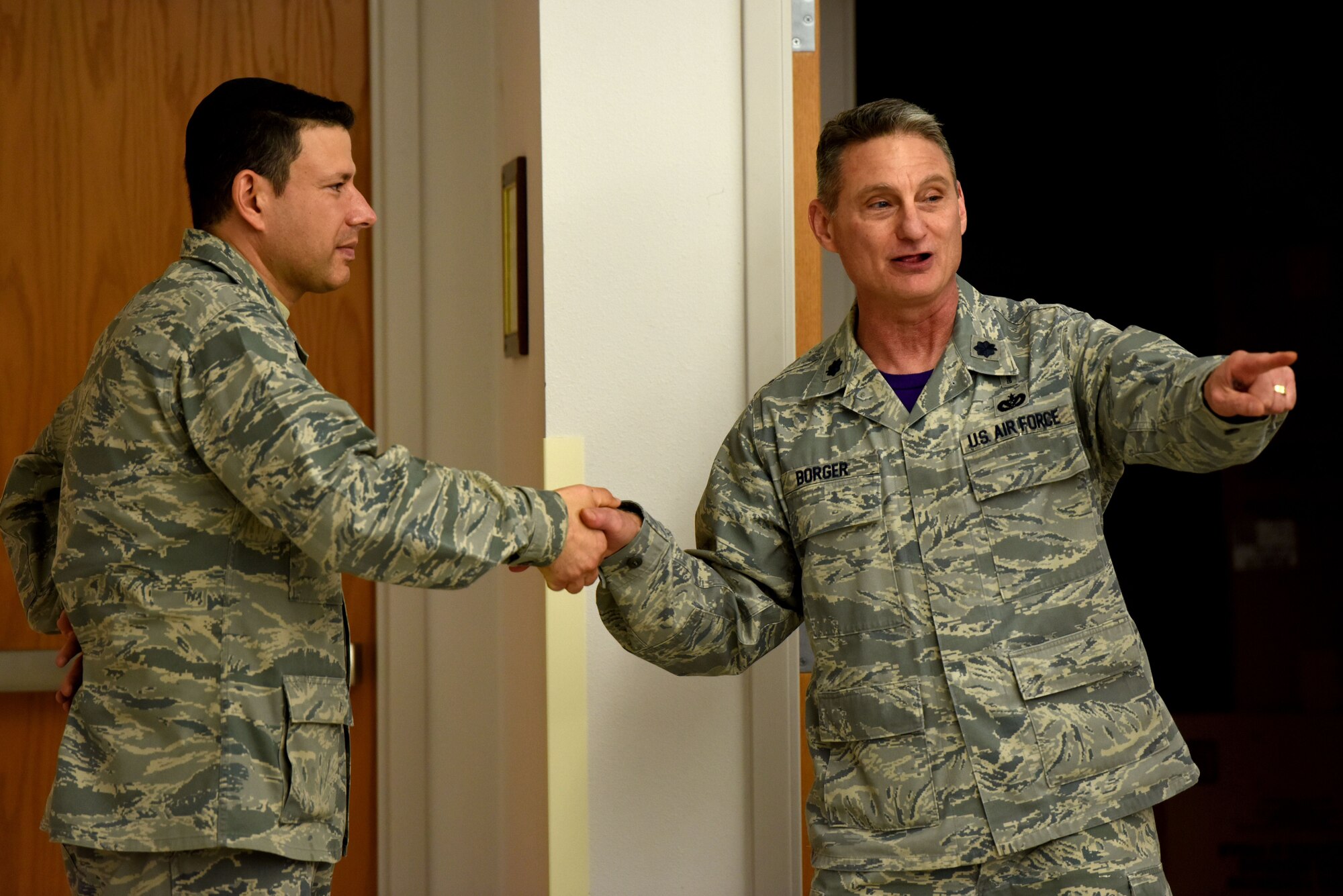 U.S. Air Force Lt. Col. Robert Borger (right), 17th Training Wing chaplain, presents Maj. Mark Edelstein (left), 502 Air Base Wing chaplain, with a chaplain’s coin as a thank you for making the trip to Goodfellow Air Force Base, Texas, Dec. 15, 2017. Edelstein traveled all over the state of Texas performing Menorah lighting ceremonies for many bases. (U.S. Air Force photo by Airman 1st Class Seraiah Hines/Released)