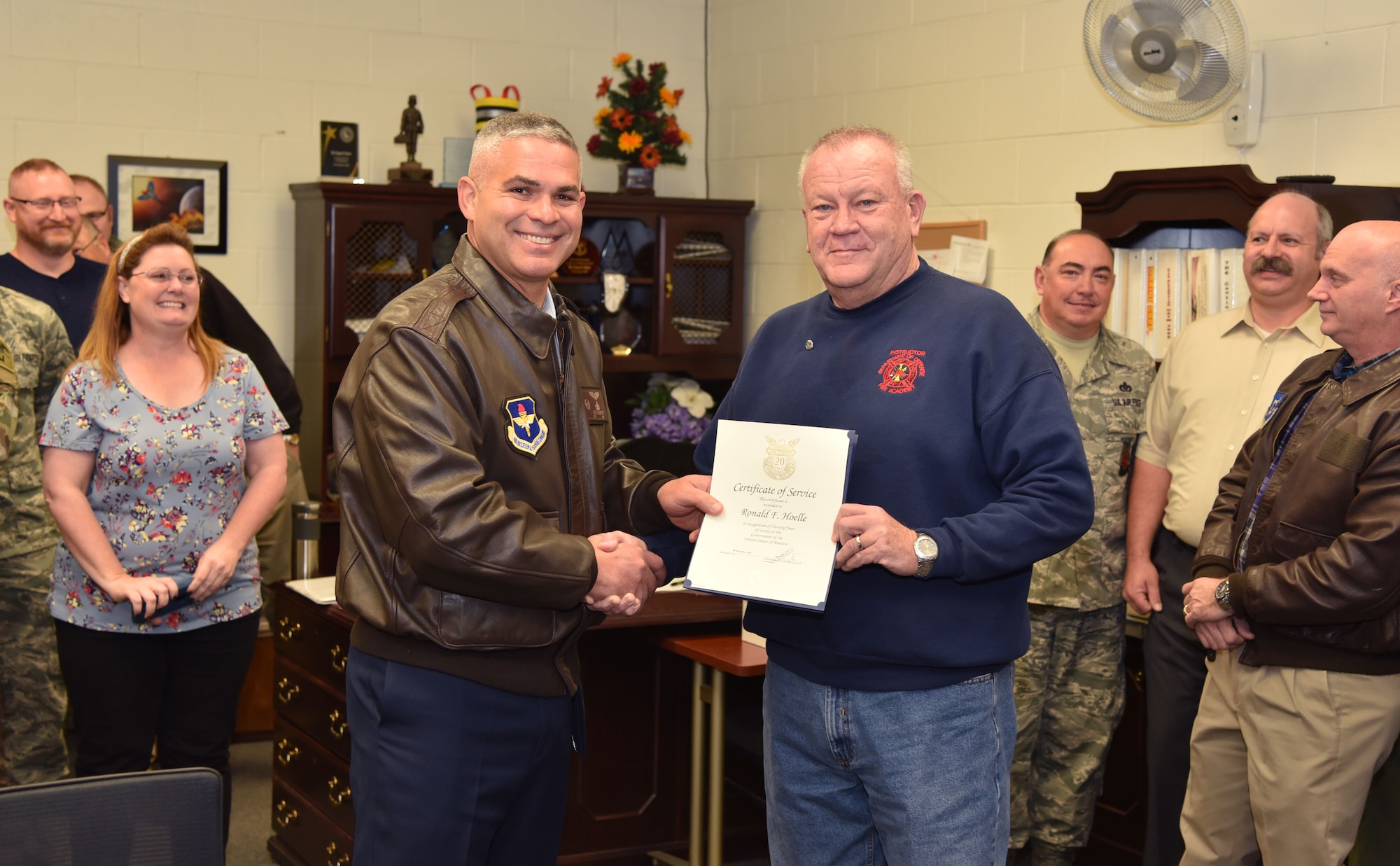 U.S. Air Force Col. Alejandro Ganster, 17th Training Group commander, presents a 20 year recognition certificate to Ronald Hoelle, 312th Training Squadron training developer, at Goodfellow Air Force Base, Dec. 7, 2017. Hoelle has been working with the 17th TRG for the entirety of his career as a civilian. (U.S. Air Force photo by Russell Stewart/Released)