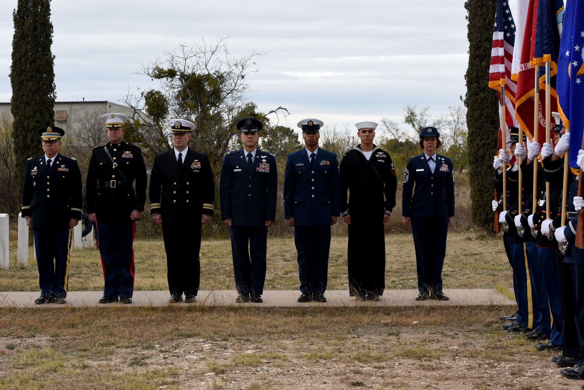 Commanders, active duty service members and the Goodfellow Color Guard stand at attention during the Wreaths Across America ceremony at Belvedere Memorial Park, San Angelo, Texas, Dec. 16, 2017. A representative from each branch laid a wreath for those who gave the ultimate sacrifice while serving. (U.S. Air Force photo by Airman 1st Class Seraiah Hines/Released)