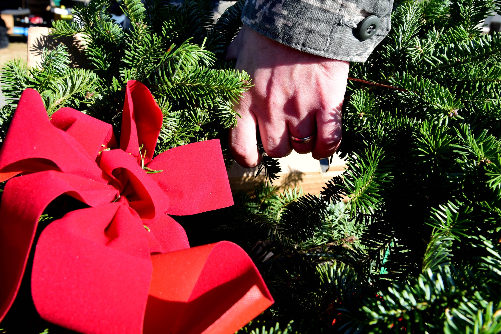 Staff Sgt. Charles Jones, 4th Logistics Readiness Squadron NCO in charge of training and mobility, hands out wreaths to be placed on the graves of fallen service members during the Wayne County Wreaths Across America ceremony Dec. 16, 2017, at Evergreen Memorial Cemetery in Princeton, North Carolina.