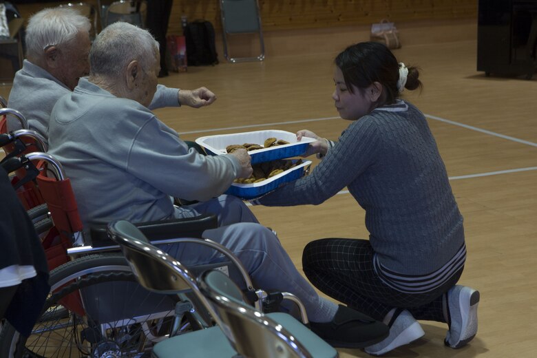 NAGO, OKINAWA, Japan— A staff member passes out cookies Dec. 15 at the Okinawa Airakuen Sanatorium in Nago, Okinawa, Japan.
