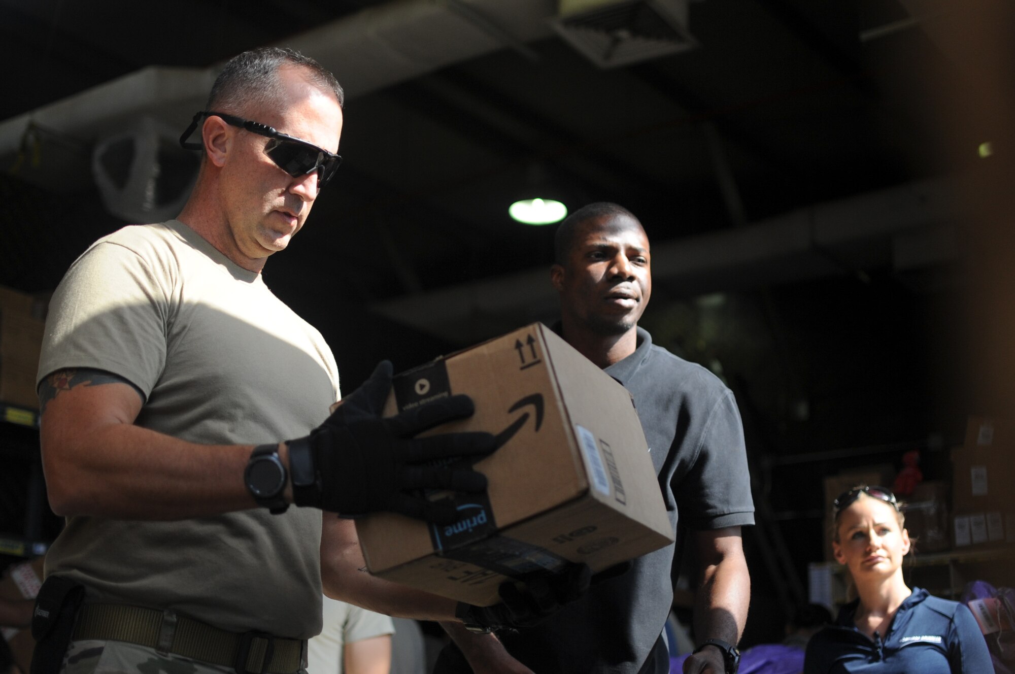 Volunteers from the 380th Air Expeditionary Wing, Al Dhafra Air Base, United Arab Emirates, work together sorting incoming packages at the post office Dec. 13, 2017. The base post office has received more than 50,000 pounds of mail this holiday season. (U.S. Air National Guard photo by Staff Sgt. Colton Elliott)