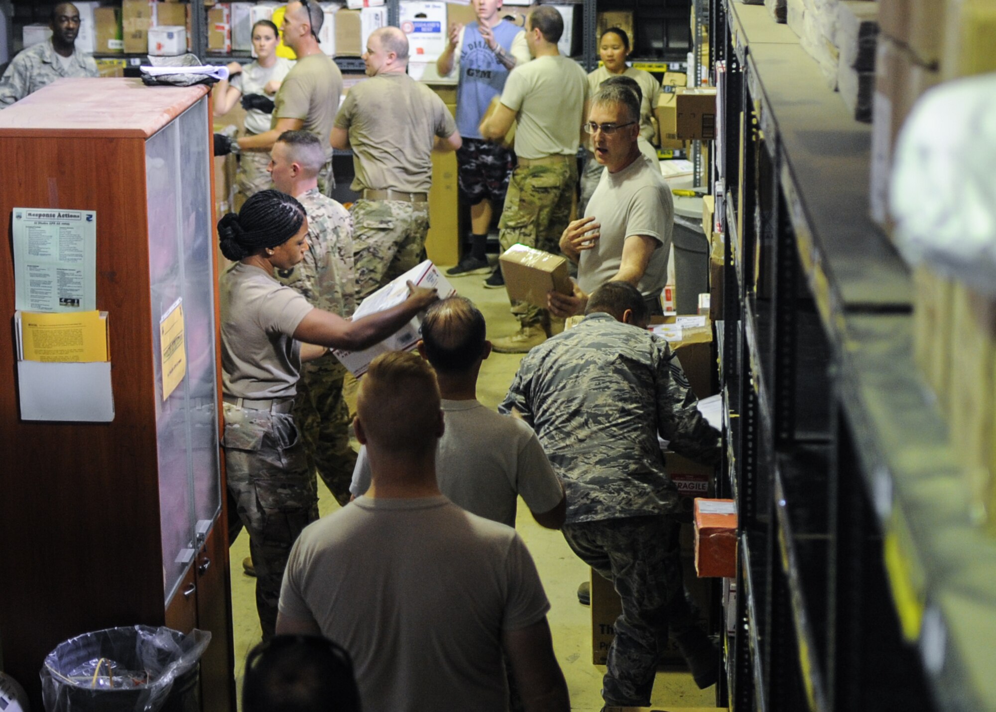 Photo By Staff Sgt. Colton Elliott | Volunteers from the 380th Air Expeditionary Wing, Al Dhafra Air Base, United Arab Emirates, help sort incoming mail on Dec. 13, 2017. The base post office has received more than 50,000 pounds of mail this holiday season. (U.S. Air National Guard photo by Staff Sgt. Colton Elliott)