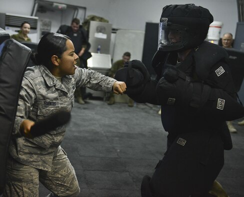 Staff Sgt. Maria Fuentes, 380th Expeditionary Security Forces, holds her baton while giving verbal instructions to 1st Lt. Michael Thrasher during ASP Baton training at Al Dhafra Air Base, United Arab Emirates Dec. 1, 2017. During this training members have the opportunity to demonstrate defense techniques using the ASP Baton against opponents dressed in redman gear. 
 (U.S. Air Force photo by Tech. Sgt. Anthony Nelson Jr)