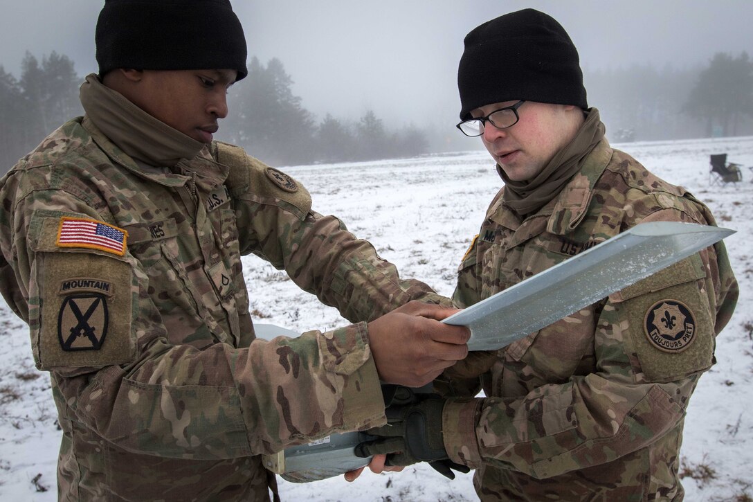 Army Pfc. Alexander Jones, left, and Army Cpl. Arlan McCoy assemble a Raven Unmanned Aerial Vehicle.