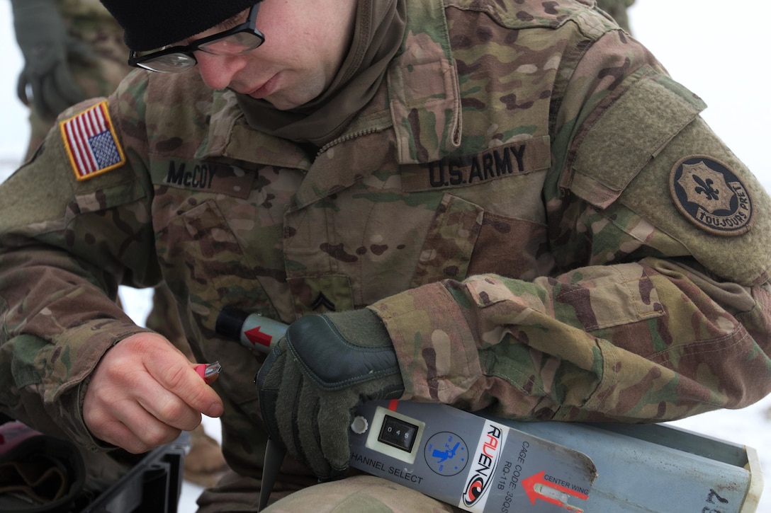 Army Cpl. Arlan McCoy repairs the channel select device and a broken prop on a Raven Unmanned Aerial Vehicle.
