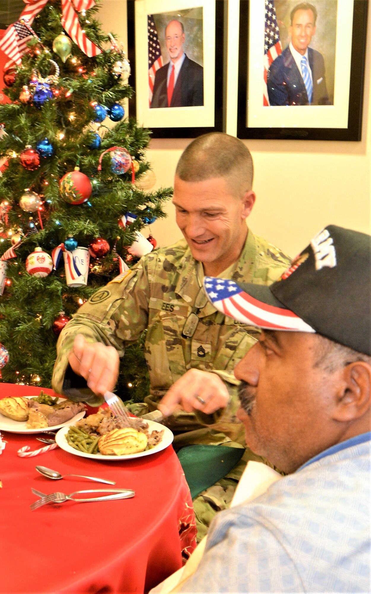 Sgt. 1st Class Timothy Sees, Delta Company, Pa. Army National Guard recruiter based out of the Southampton Armory, Philadelphia, serves a meal to a resident of the Delaware Valley Veteran’s Home, Philadelphia, Dec. 14, 2017. Pa. Air and Army Guardsmen visited residents and their families for a holiday-themed event. (U.S. Air National Guard photo by Tech. Sgt. Andria Allmond)