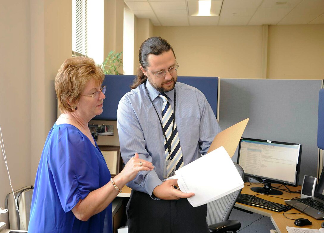 Robert Steed, a contracting officer for DLA Disposition Services, discusses a new contract with Sheryl Woods, DLA Disposition Services’ special assistant for small business.