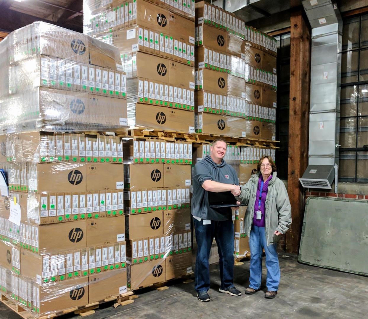 District Technology Supervisor Ryan Stockton of Ohio’s Minford Local School District shakes the hand of DLA Disposition Services Property Disposal Specialist Cindy Anderson as he prepares to load up 1,300 excess laptops that no longer met DoD security requirements.