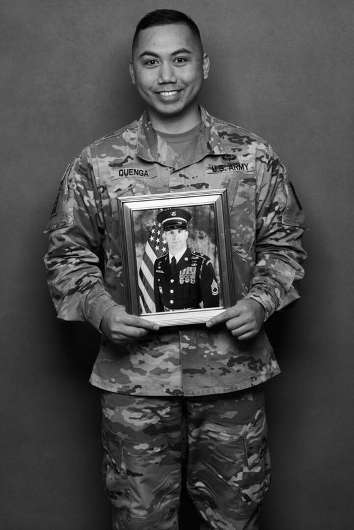 Army Capt. Joseph Quenga stands with a photo