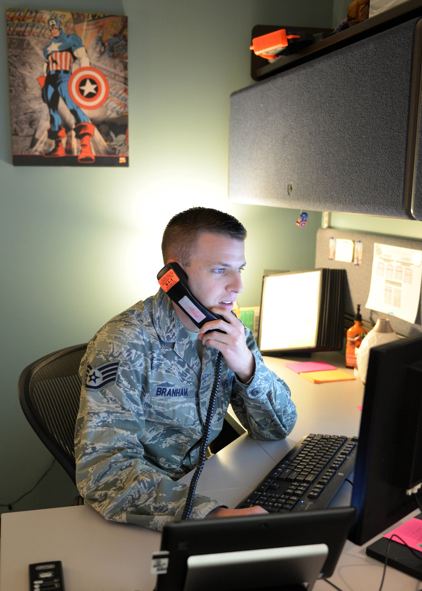 U.S. Air Force Staff Sgt. Adam Branham, Preventative Health Cell noncommissioned officer in charge, 673d Aerospace Medicine Squadron, answers the phone at Joint Base Elmendorf-Richardson, Alaska, Nov. 30, 2017. At JBER, the Preventative Health Assessment Cell monitors and tracks those who have completed the PHA questionnaire and is notified when the mental health assessment is scheduled and completed.