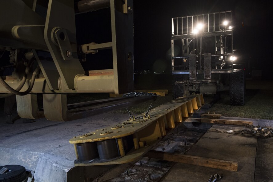 A fairlead beam hovers while supported by two forklifts, Nov. 15, 2017, at Moody Air Force Base, Ga. The beam is a part of a BAK-12 arresting system that is used on the runway to slow down fighter aircraft in emergency situations. This beam has been on Moody’s flightline since 1998, but under new guidelines will now be replaced every 10 years. (U.S. Air Force photo by Senior Airman Janiqua P. Robinson)