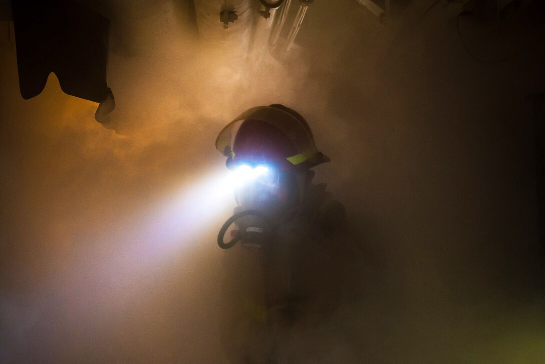 A seaman navigates through the smoke.