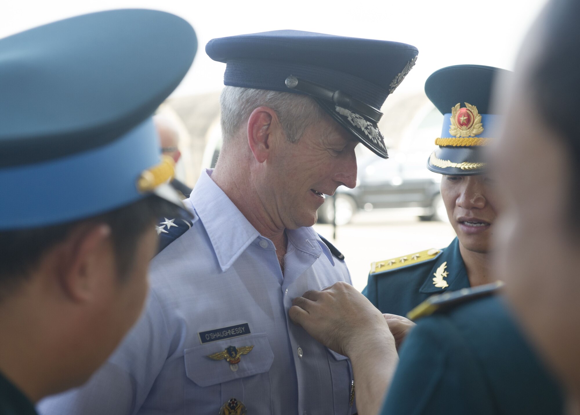 Vietnamese Air Defense-Air Force 935th Regiment staff pin their wings on Gen. Terrence J. O’Shaughnessy, Pacific Air Forces commander, as a gesture of respect during a visit to Bien Hoa Air Base, Vietnam, Dec. 16.