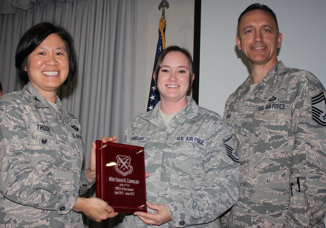 Col. Janette Thode, 340th FTG commander, and superintendent Chief Master Sgt. Jimmie Morris present the second quarter Senior NCO of the Quarter award to Master Sergeant Sarah Cornelius, information technology superintendent, during the December 2017 mandatory unit training assembly. (U.S. Air Force photo)