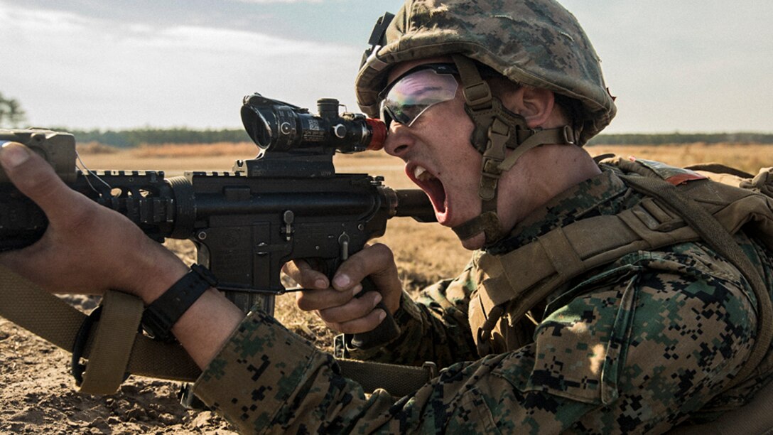 A Marine calls out as he aims his weapon during training.