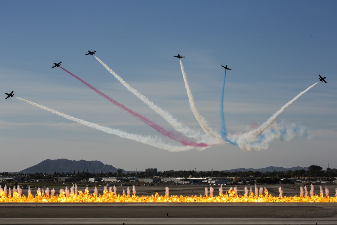 The Patriots Jet Team performs aerial acrobatics as pyrotechnics provided by the Tora Bomb Squad of the Commemorative Air Force explode, forming a "Wall Of Fire" during the 2017 Yuma Airshow at Marine Corps Air Station Yuma, Ariz., Saturday, March 18, 2017. (U.S. Marine Corps photo taken by Lance Cpl. Christian Cachola)