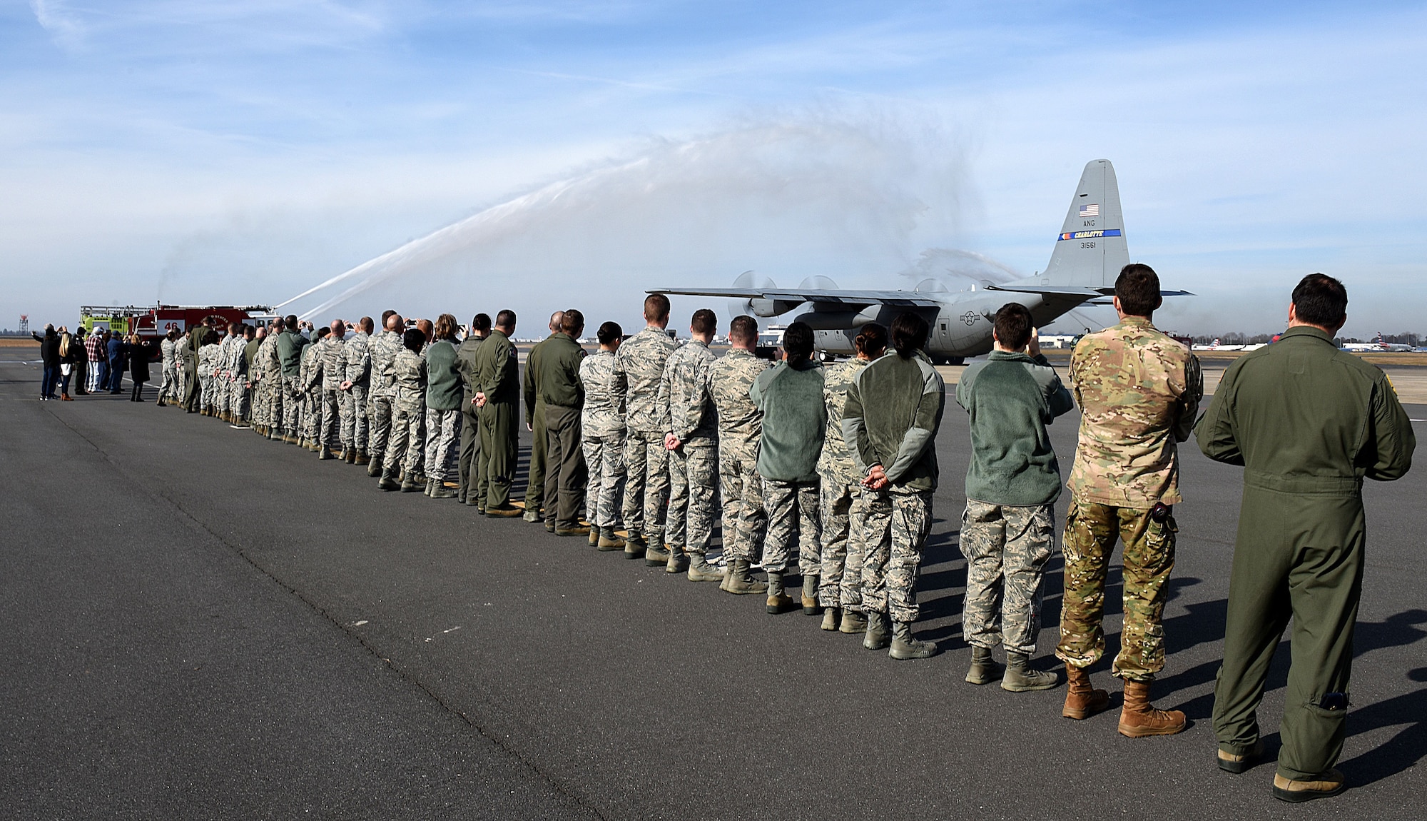 Spectators watch a ceremonious final flight wash as the last C-130 Hercules aircraft attached to the North Carolina Air National Guard Base, Charlotte Douglas International Airport departs for a new assignment at the 165th Airlift Wing in Savannah, Georgia, Dec. 18, 2017. The NCANG is in transition from flying the C-130 Hercules to C-17 Globemaster III aircraft. The change in mission will require not only a transition in aircraft and personnel, but an increase in structures throughout the base.