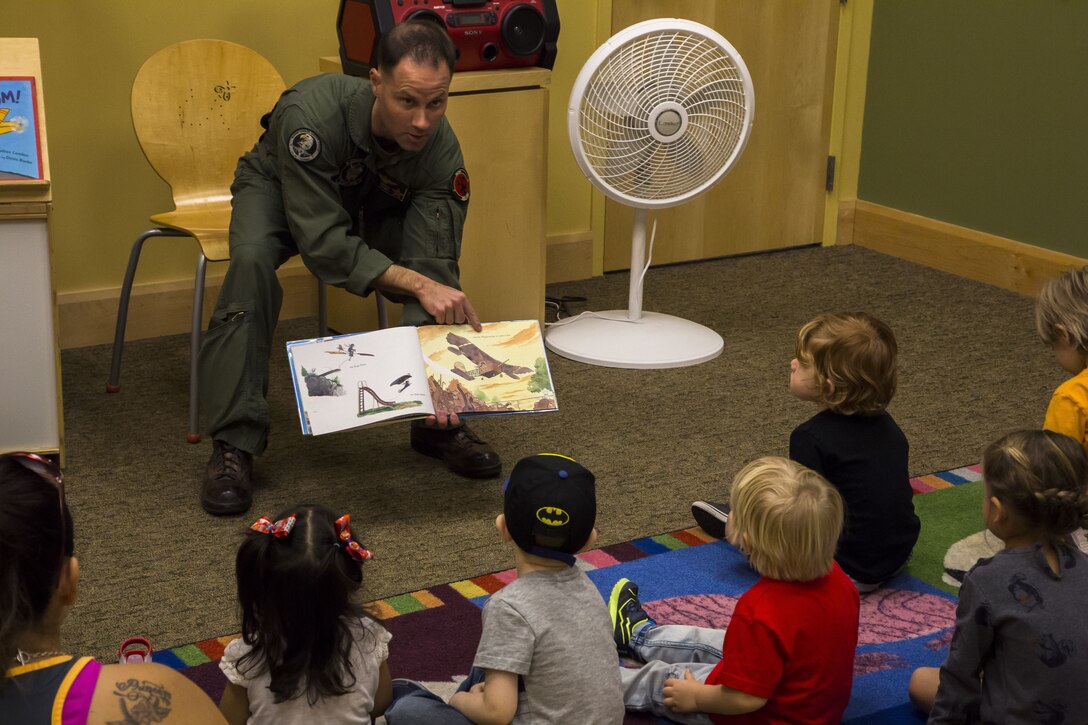 U.S. Marine Corps Maj. Benjamin D. Apple, the operations officer for Marine Fighter Training Squadron 401 (VMFT-401), stationed out of Marine Corps Air Station Yuma, Ariz., reads "Violet Pilot," an aviation-themed children's book to families at the main Yuma County Library, Wednesday, Feb. 15, 2017. (U.S. Marine Corps photo by Lance Cpl. Christian Cachola/Released)