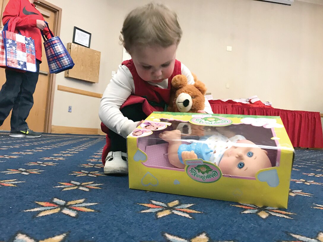 Zoey Mills, 2, opens her present from Santa. She also celebrated her birthday Dec. 16 during the Hearts Apart Kids’ Christmas Party. More than 100 people attended this year’s event.