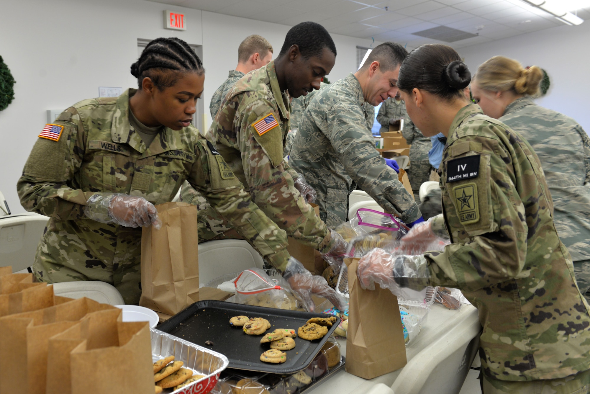 U. S. Army Pvt. Kiara Wells, 344th Military Intelligence Battalion trainee and Pvt. John Tracy, 344th MIBN trainee, prepare bags of cookies at the Taylor Chapel on Goodfellow Air Force Base, Texas, for distribution to Goodfellow trainees Dec. 20, 2017. Over 40 volunteers gathered at the Taylor Chapel to provide some holiday cheer by filling bags full of cookies for Goodfellow Airmen before they leave for the holidays.