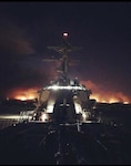 USS Sterett (DDG 104) moores in Port Hueneme as the Ventura County hills endure rampant fires, Dec. 5. The destroyer visited Naval Surface Warfare Center, Port Hueneme Division for a combat systems assessment and groom.