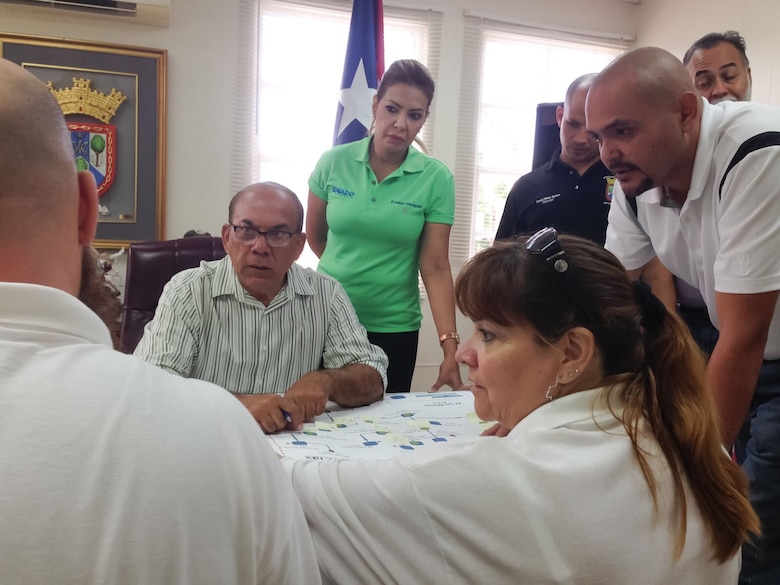 Sandra Eudy (center), an Emergency Management Specialist with South Pacific Division, talks with members of the Puerto Rican government. Hurricane Maria struck Puerto Rico and the U.S. Virgin Islands in mid-Sept.