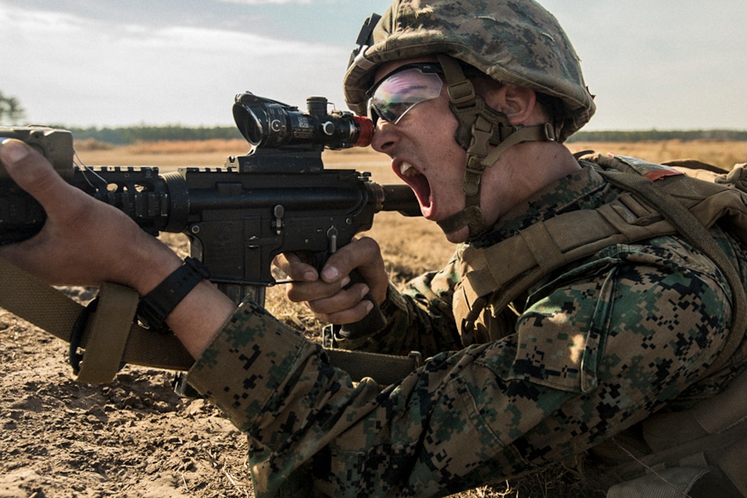 A Marine calls out as he aims his weapon during training.