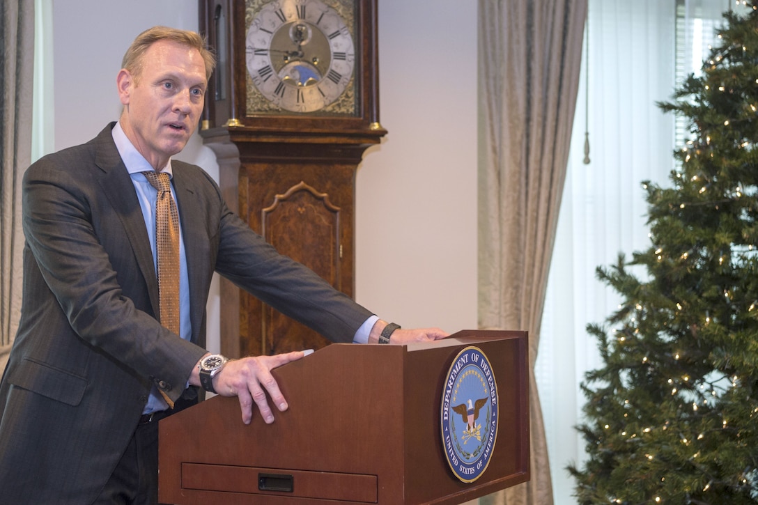 The deputy defense secretary speaks from behind a podium.