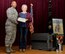 U.S. Air Force Lt. Col. Lawrence Wyatt Jr., 100th Security Forces Squadron commander, presents a Certificate of Appreciation to Debbie Black, 100th SFS kennel maid Dec. 20, 2017, on behalf of Military Working Dog Gina, who passed away Nov. 27. Black, was going to adopt Gina when she was due to retire in August 2018 and had cared for Gina since the MWD’s first day at RAF Mildenhall in July 2009. (U.S. Air Force photo by Karen Abeyasekere)