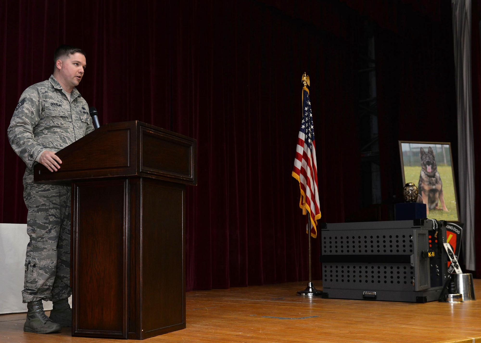 U.S. Air Force Staff Sgt. James Douglas, 100th Security Forces Squadron Military Working Dog handler, shares stories of his former K-9 partner, MWD Gina, at the memorial ceremony in her honor at RAF Mildenhall, England, Dec. 20, 2017. Gina passed away Nov. 27, following the discovery of an inoperable tumor. (U.S. Air Force photo by Karen Abeyasekere)