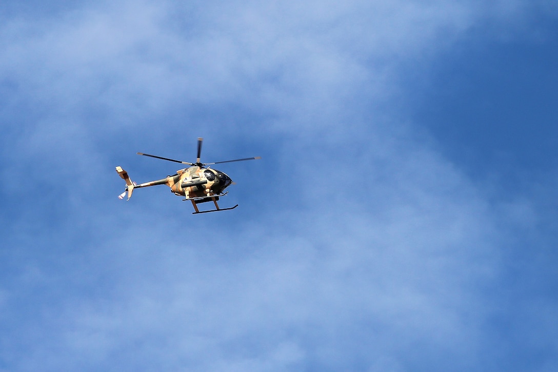 An Afghan air force MD-530 helicopter flies above Camp Shroabak