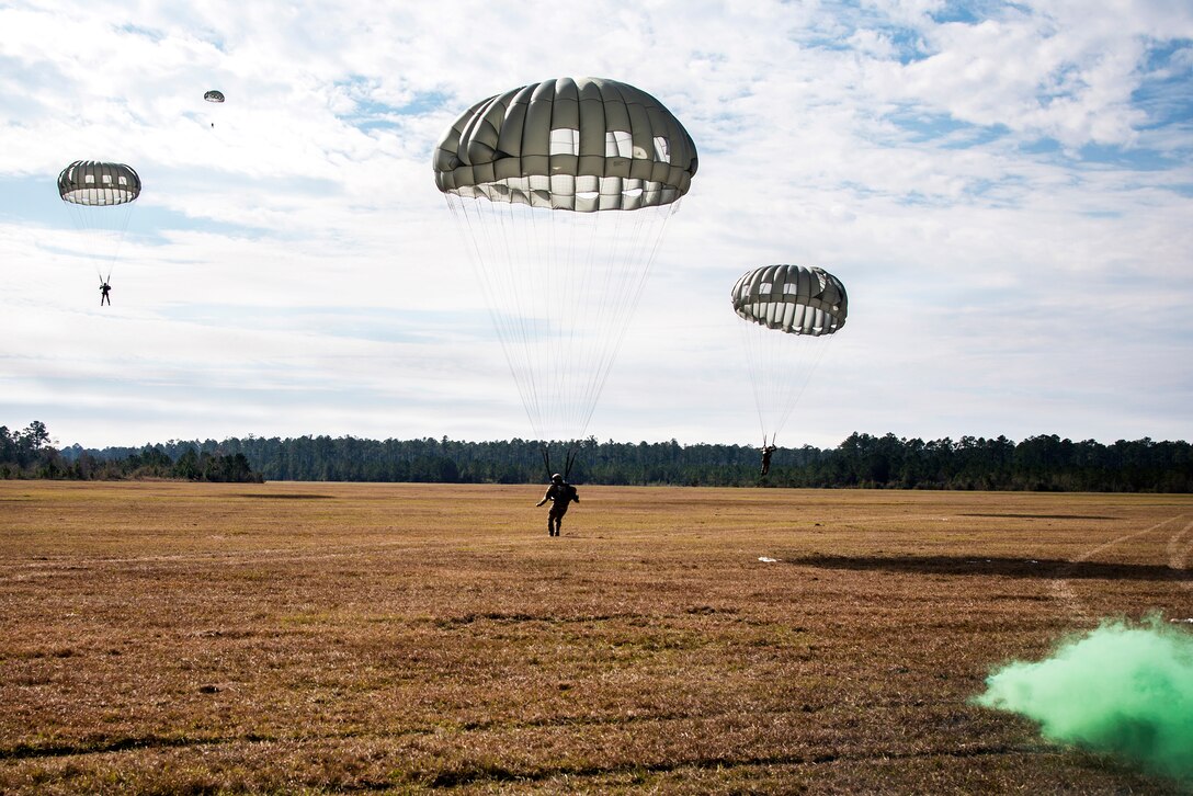 Air Force pararescuemen descend to the drop zone during an exercise.