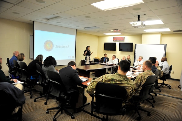 Lacey Thomasson (Standing), Silver Jackets coordinator with the U.S. Army Corps of Engineers Nashville District, briefs leadership from the Nashville District, Memphis District, Tennessee Emergency Management Agency and Tennessee National Guard during a partnering meeting at TEMA Headquarters in Nashville, Tenn., Dec. 19, 2017. (Photo by Matthew Starling)