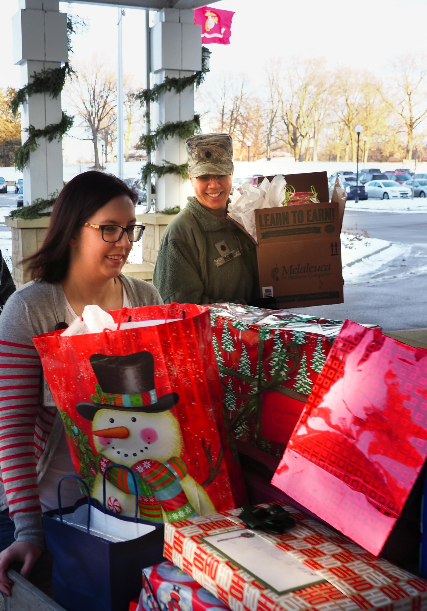 Kate Gorski, Minnesota Veteran's Home and Lt. Col. Karen Rowe, 934 FSS, carry gifts donated by 934 AW Airmen to the Minnesota Veteran's Home Dec. 19. (Air Force Photo/Paul Zadach)