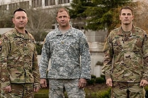 Three soldiers pose for a photograph.