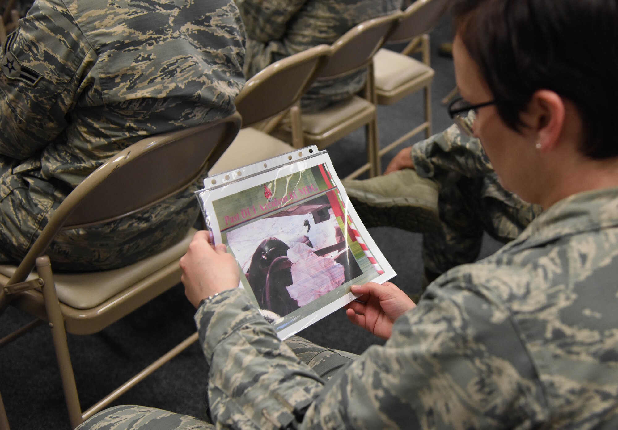 Capt. Rachel Donoho, 81st Communications Squadron operations flight commander, looks at a past DUI accident slide during an alcohol awareness briefing at the 81st CS Dec. 19, 2017, on Keesler Air Force Base, Mississippi. December is Impaired Driving Awareness Month. More than 200 people were killed in Mississippi last year in drunk driving related incidents. (U.S. Air Force photo by Kemberly Groue)